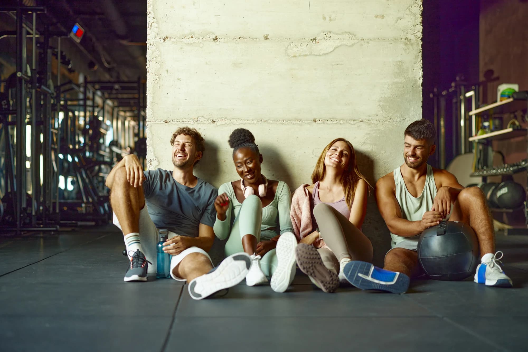 Diverse group of friends laughing together at the gym