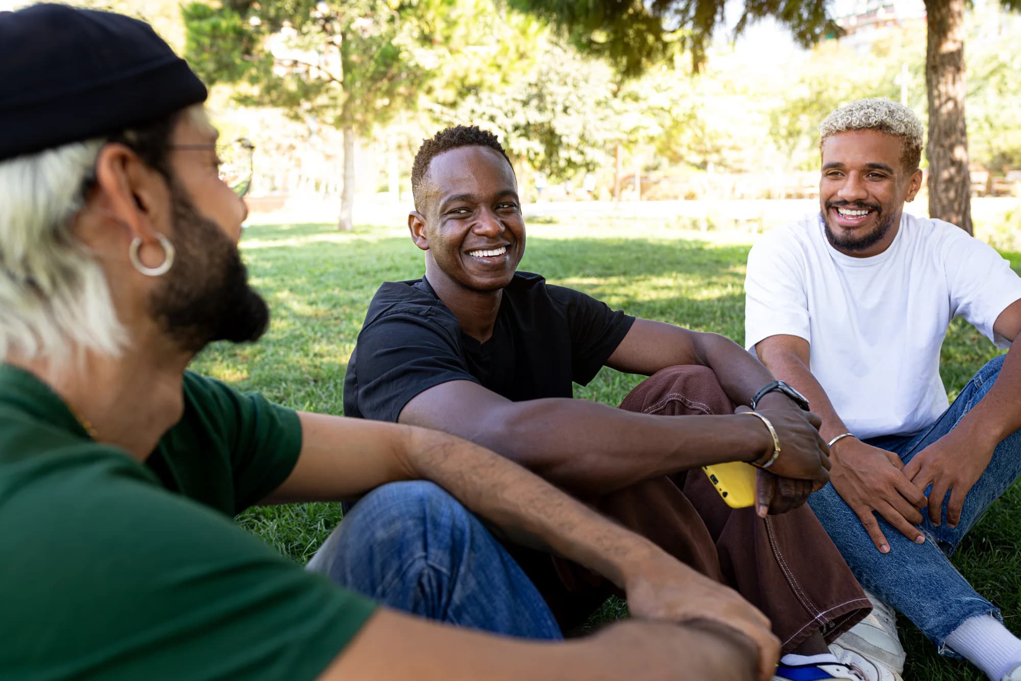 Young men relaxing and talking together in a park